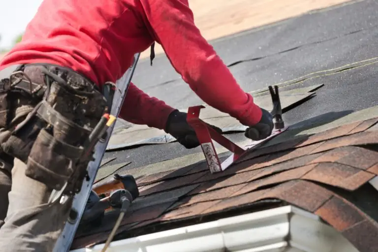 Roofer replacing asphalt shingles on a house roof