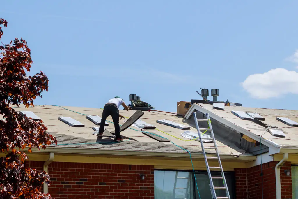 Roofers repairing a house roof