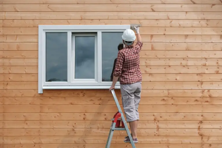 Worker finishing exterior wall siding